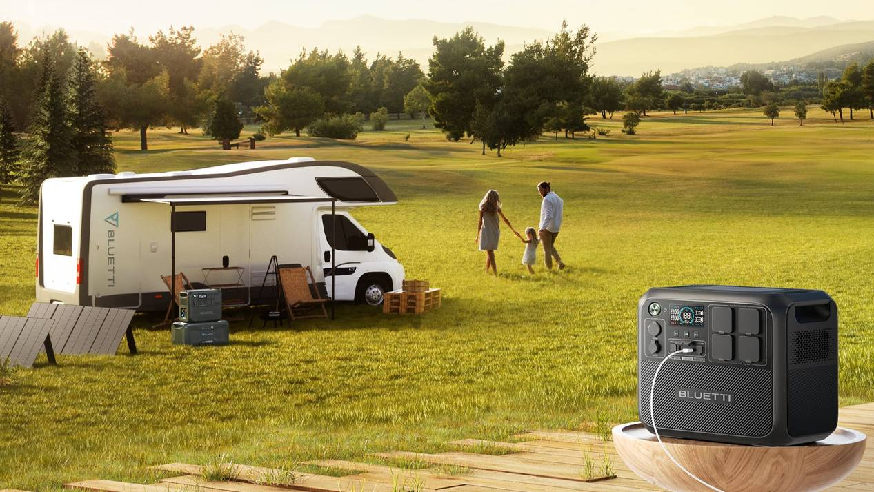 Bluetti portable power station in use for outdoor camping with solar panel charging.