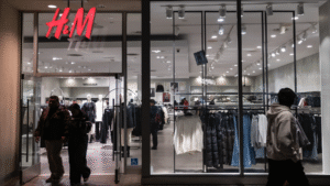 Teenagers enthusiastically exploring trendy fashion in a vibrant H&M store.