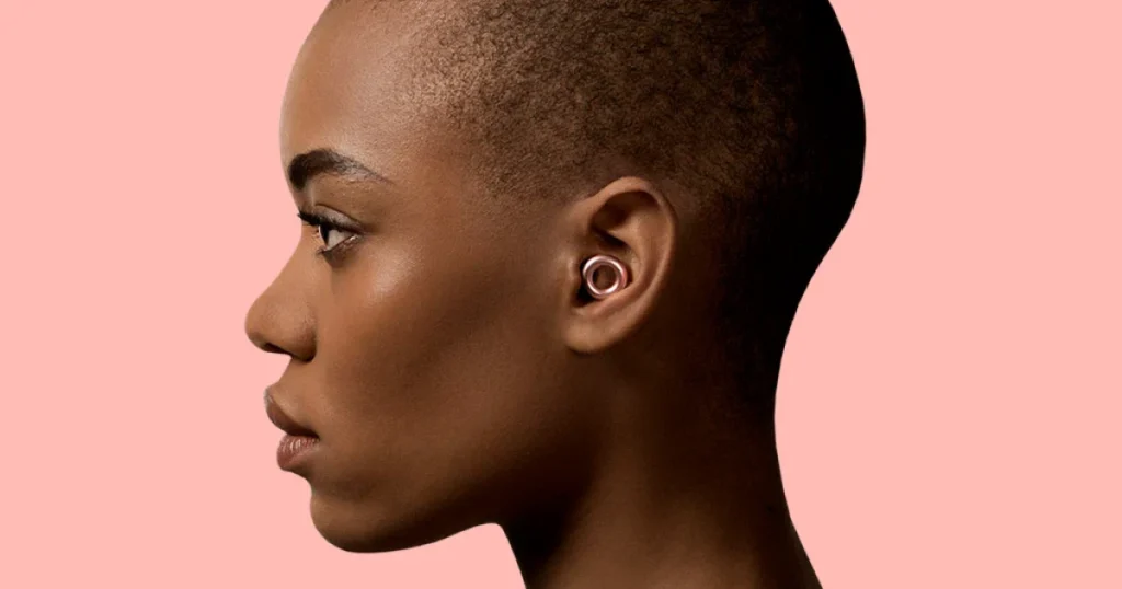 Close-up of various colored Loop Earplugs laid out on a clean surface, showcasing their sleek, circular design.