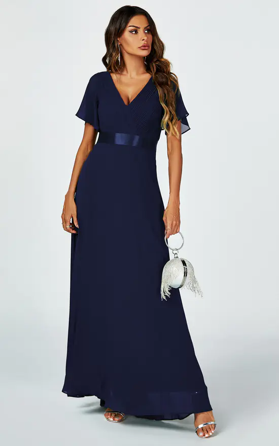 Stylish apple dress body type woman in a flattering navy empire-waist dress.