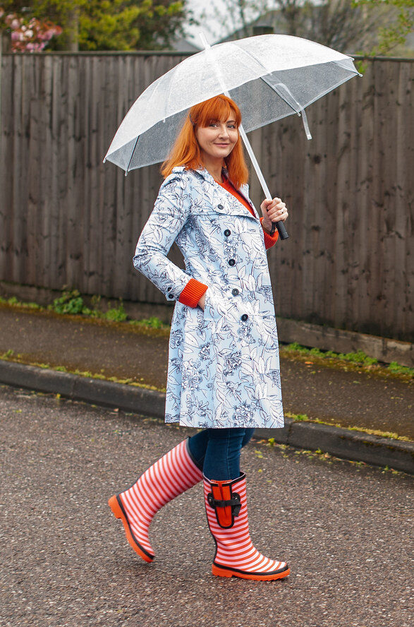 Stylish person in monsoon fashion with umbrella and waterproof boots