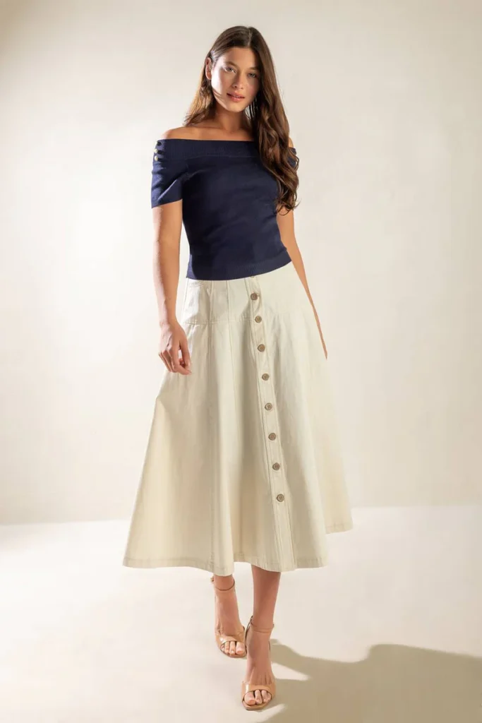 Fashionable pear-shaped woman in a floral off-shoulder top and dark blue A-line skirt